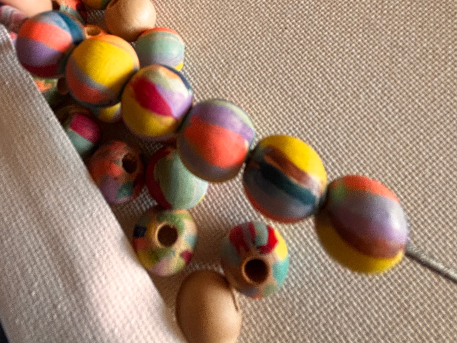Painted beads on a pin and some loose beads below