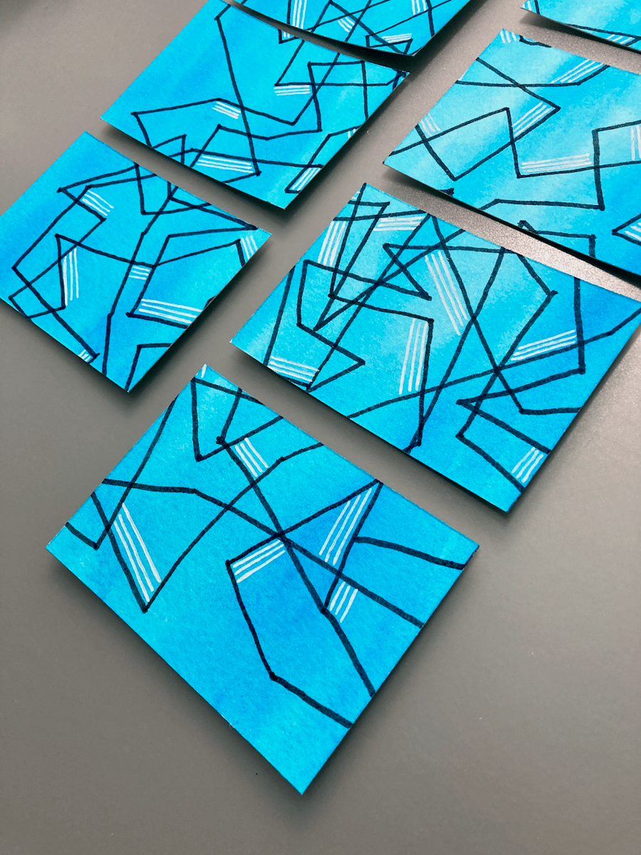 Close up of cards with a blue background and abstract black and white lines.