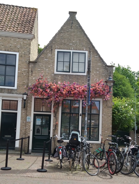 a house with gorgeous flowers on the gable, lots of bikes in front (welcome to the Netherlands, bike country!)
